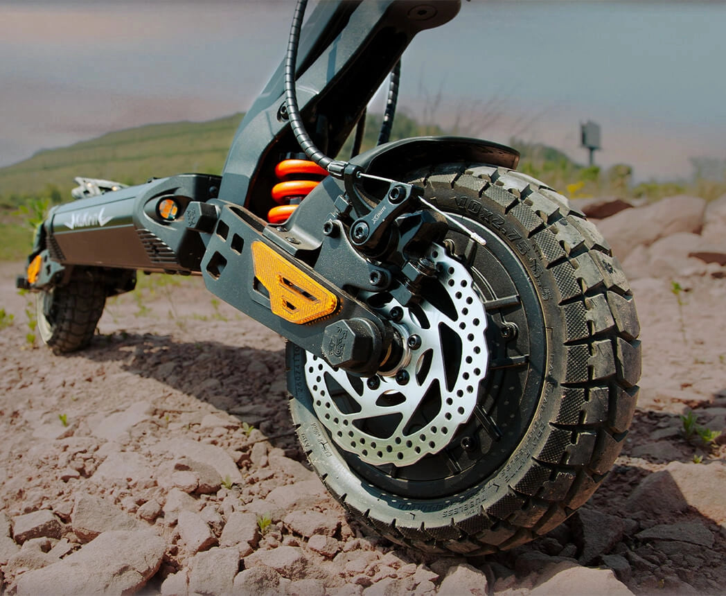 Close-up of KuKirin G2 Master front hydraulic shock absorber suspension on dirt trail.