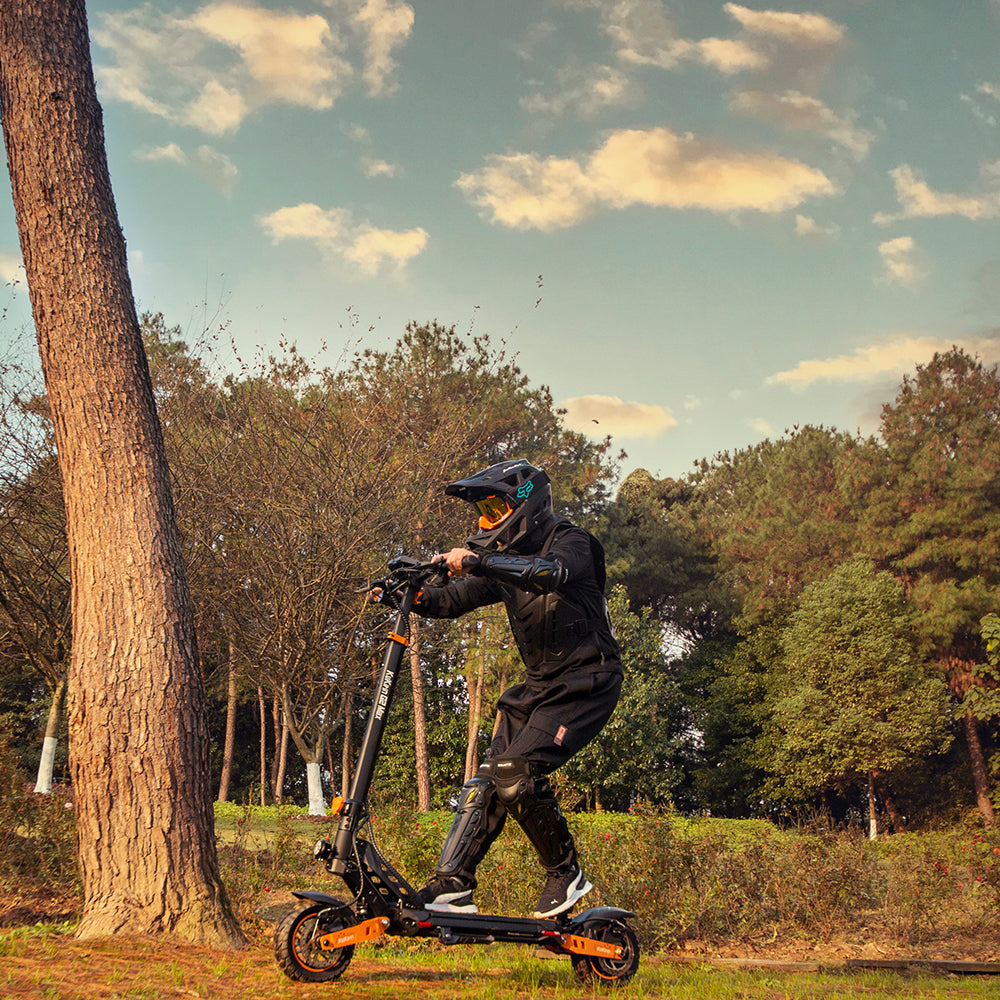 Riding the KuKirin G2 Max off-road electric scooter on a forest trail.
