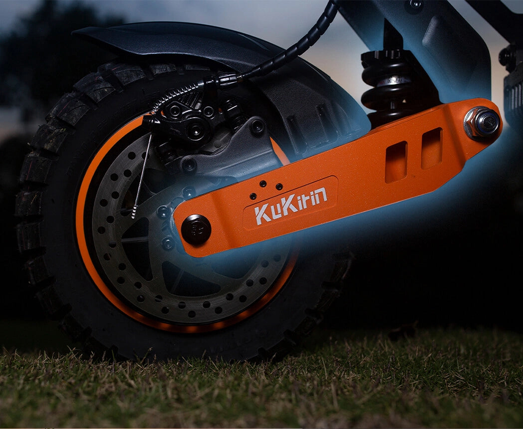 Gros plan sur la suspension arrière robuste à quatre bras et le bras oscillant orange d'un KuKirin G2 Max.