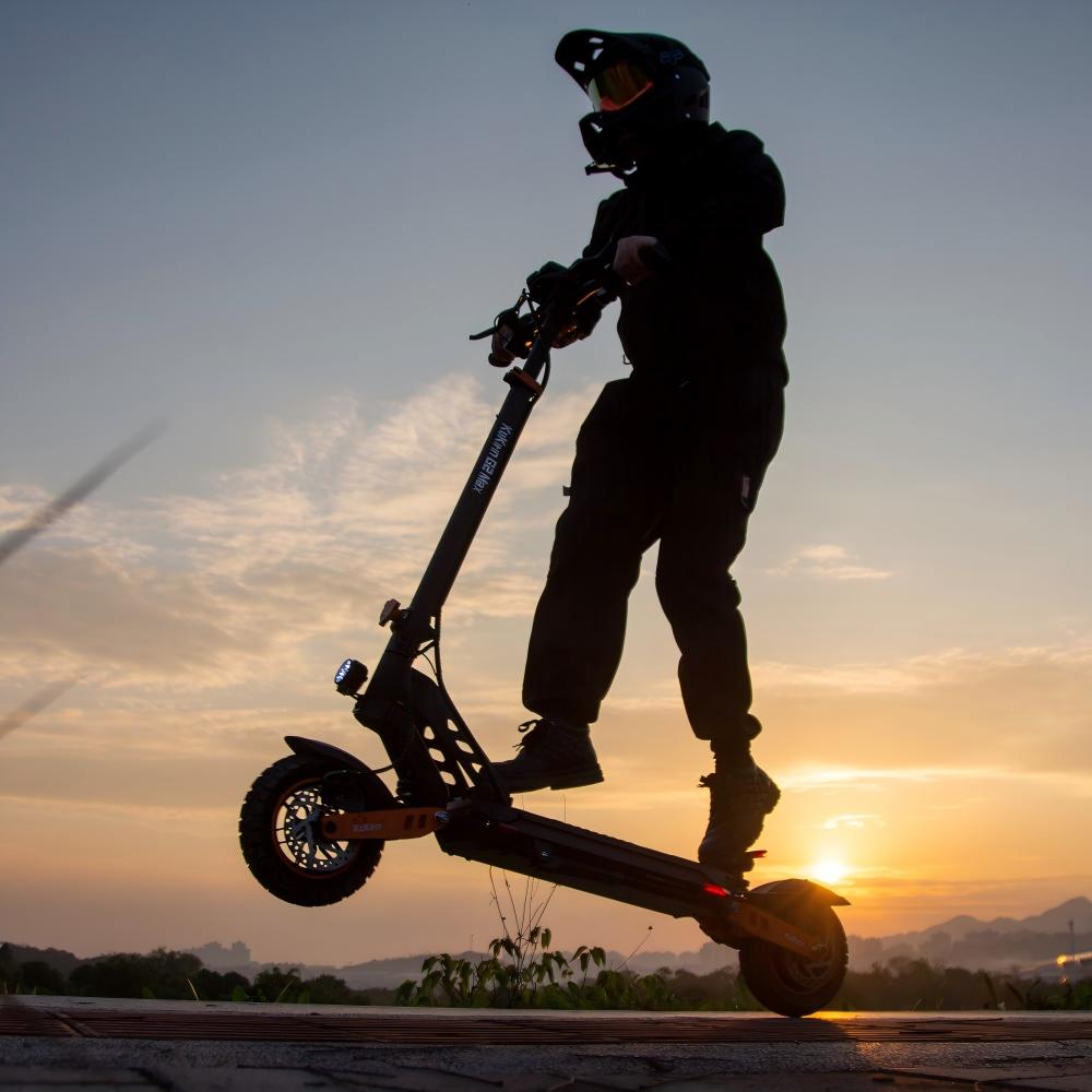 KuKirin G2 Max performing a high-torque front wheel lift at sunset