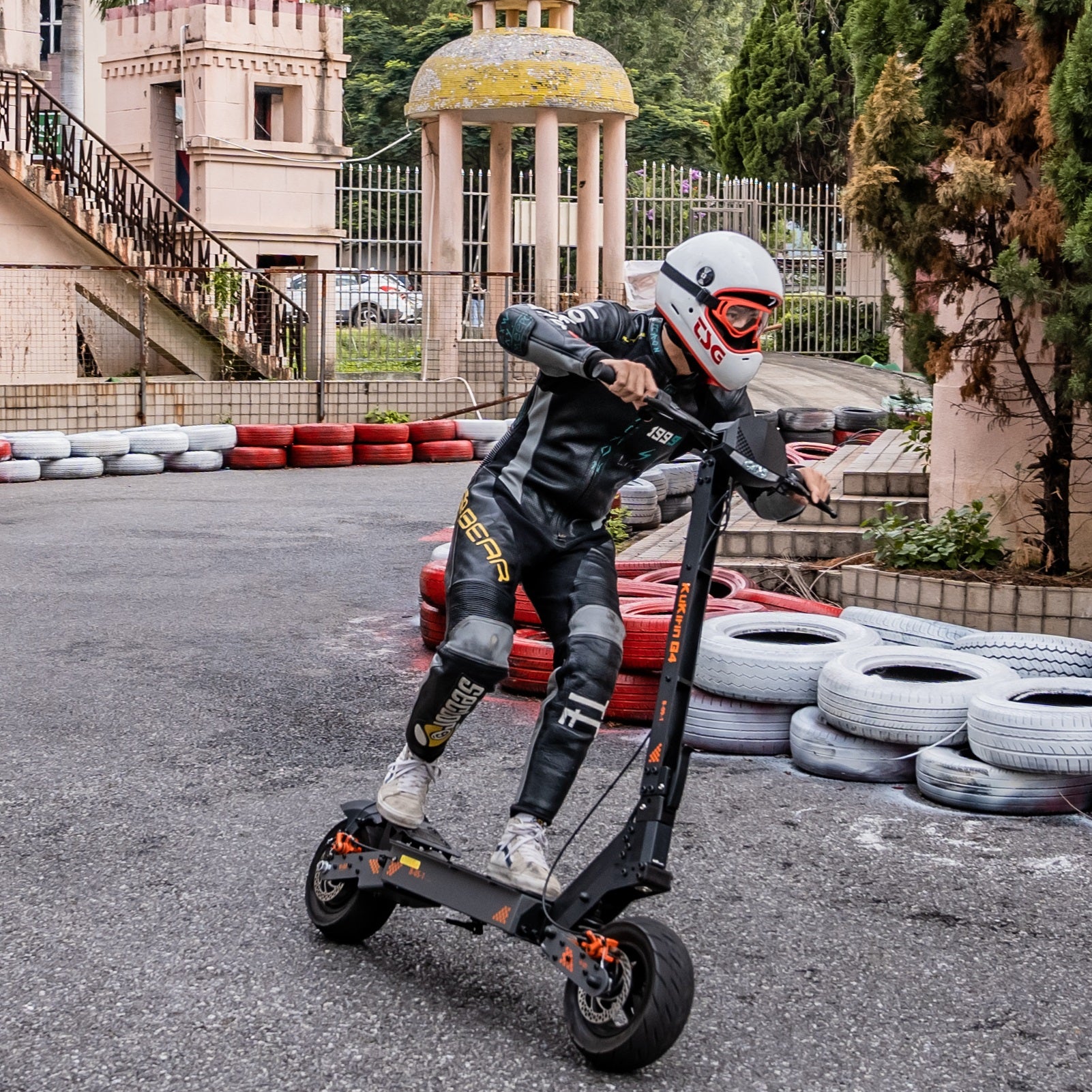 Rider in safety gear cornering on a KuKirin G4 electric scooter